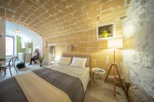 Minervino MurgeLa Ferula Magica - alloggio tipico的一间卧室设有一张床和砖墙