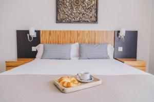 Estepona纳瓦尔罗马诺高尔夫度假村的床上的羊角面包和咖啡托盘