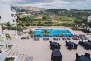 Estepona纳瓦尔罗马诺高尔夫度假村的从酒店阳台可欣赏到游泳池的景色