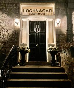 阿伯丁Lochnagar Guest House的一座带楼梯的黑色旅馆前门
