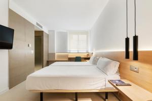 托雷利亚诺槟榔树酒店的卧室配有一张白色大床和一张书桌