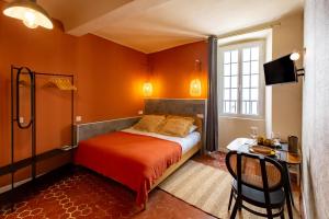 戛纳Le Saint Victor Coeur de Cannes的一间卧室配有一张床、一张桌子和一台电视