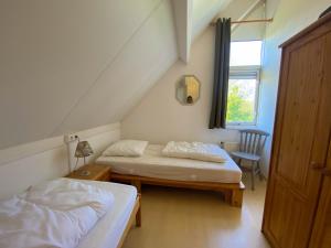 布雷斯肯斯Hello Zeeland - Vakantiehuis Zwin 019的客房设有两张床、一张桌子和一扇窗户。