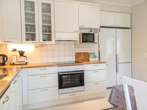 尼尔西艾埃诺拉别墅度假屋 的白色的厨房配有白色橱柜和冰箱。