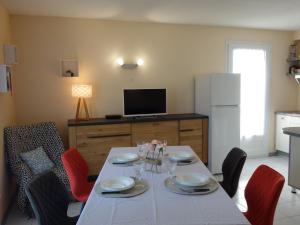 朋泰雷克Apartment Les Jardins de l'Eden by Interhome的一间设有白色桌子和红色椅子的用餐室
