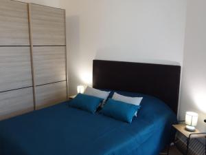 朋泰雷克Apartment Les Jardins de l'Eden by Interhome的一间卧室配有蓝色的床和2个蓝色枕头