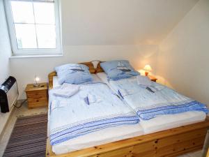 高尔维茨Apartment Gollwitzer Park - Insel Poel-2 by Interhome的一间卧室配有两张带蓝色枕头的床和窗户。