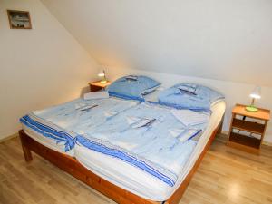 高尔维茨Apartment Gollwitzer Park - Insel Poel-8 by Interhome的一间卧室配有一张带蓝色床单和蓝色枕头的床。