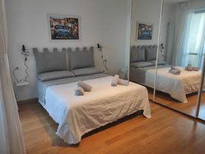 佩斯卡拉CasaBelvedere Vista Mare e Comfort的一间带两张床和镜子的客厅