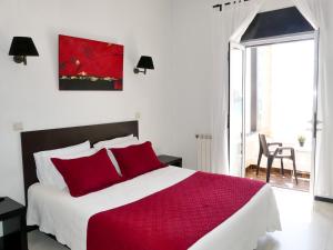 纳扎雷库巴塔酒店的一间卧室配有一张带红色枕头的大床