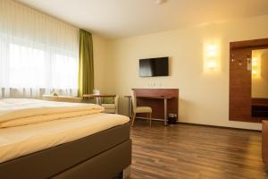 美因河畔霍海姆维奥拉酒店的配有一张床和一张书桌的酒店客房