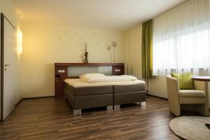 美因河畔霍海姆维奥拉酒店的卧室配有床、椅子和窗户。