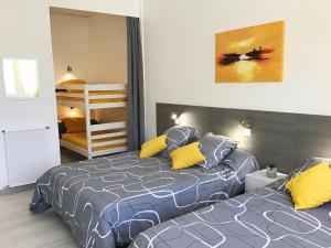 卢尔德Appartement Le Solea 100m2 climatisé parking proche Sanctuaires的一间卧室配有两张带黄色枕头的床