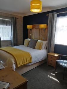 哈沃斯Park Top House的一间卧室配有一张带黄色毯子的大床