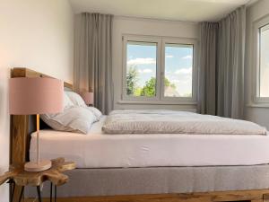 巴特弗斯劳Haderer's Home - Bad Vöslau near Vienna的卧室配有白色的床和2扇窗户。