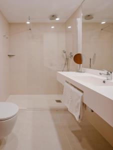 甘迪亚罗斯罗布雷斯酒店的白色的浴室设有水槽和卫生间。