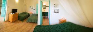 波尔兰特Les Jardins de l'Espérance的一间卧室设有两张绿色的床和镜子