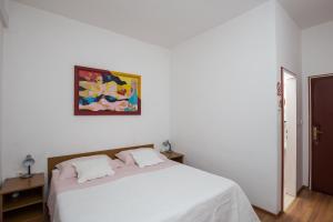 默克斯卡科纳莉可别墅酒店的卧室配有白色的床和墙上的绘画作品