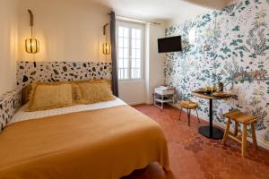 戛纳Le Saint Victor Coeur de Cannes的一间卧室配有一张大床和花卉壁纸