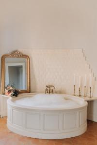 SenlisseChâteau de la Cour Senlisse的一间带浴缸、镜子和蜡烛的浴室