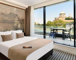 艾斯特根Grand Hotel Esztergom的酒店客房设有一张床和一个大窗户