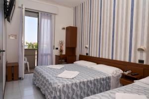 里米尼大西洋酒店的酒店客房设有两张床和窗户。