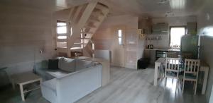 DarłówkoPrzytulny domek的一间带白色沙发的客厅和一间厨房