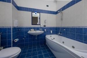 利卡塔Hotel Baia D'oro的一间带水槽、浴缸和卫生间的浴室