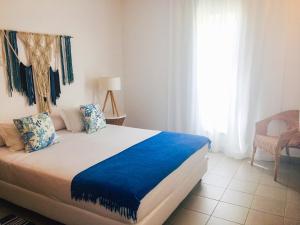 拉戈斯拉各斯游艇俱乐部度假酒店的一间卧室配有一张带蓝色床单的床和一扇窗户。