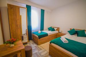 乌日策Užički konak的酒店客房设有两张床和一张桌子。