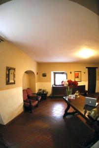 Rocca SinibaldaLa Locanda del Convento的客厅配有书桌和带笔记本电脑的桌子