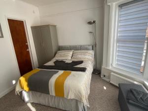 伊斯特布恩Penhale Holiday Flats的一间卧室设有一张床和一个窗口