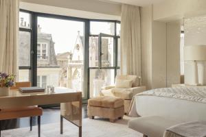 巴黎Cheval Blanc Paris & Dior Spa Cheval Blanc Paris的一间卧室配有一张床、一张桌子和一把椅子