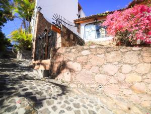 塔斯科·德·阿拉尔孔Casa de las Cruces Taxco的一座石墙和粉红色花卉的房子