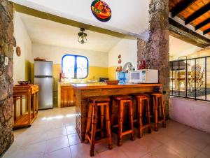 塔斯科·德·阿拉尔孔Casa de las Cruces Taxco的厨房配有带凳子的柜台和冰箱。
