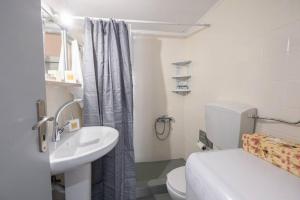 艾丽奇Nisos cottage house的浴室配有白色卫生间和盥洗盆。