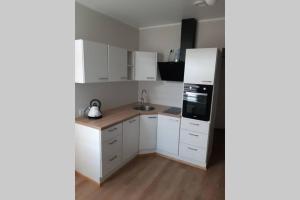 派尔努Supeluse 6/2 külaliskorter的厨房配有白色橱柜和冰箱。