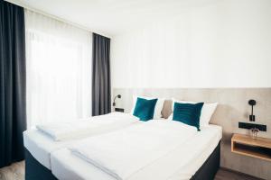 慕尼黑SmartLiving Apartments München的一间卧室配有两张白色床和蓝色枕头