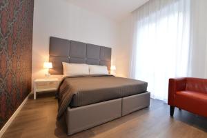 罗马弗拉米尼奥旅馆的一间卧室配有一张大床和一张红色椅子