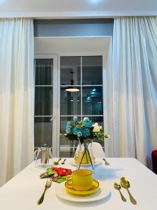 乌拉尔斯克LUX 6 МКР дизайнерская комфортная студия с панорамными дверьми и большой лоджией的一张带黄盘和花瓶的桌子