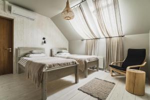 图哈Guest House Garoza的一间卧室设有两张床、一把椅子和一个窗户。