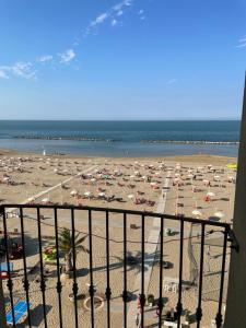 里米尼布鲁门酒店的享有海滩美景,配有遮阳伞和海洋美景。