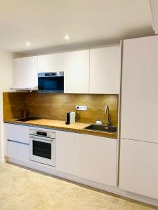 尼姆Feel@Home Nemausus « Le 21 »的厨房配有白色橱柜和水槽