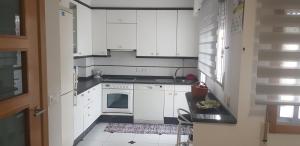 格罗韦Piso Monte Da Vila的小厨房配有白色橱柜和水槽
