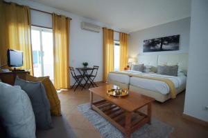 卢斯绿洲海滩公寓酒店的一间卧室配有一张床,客厅配有沙发