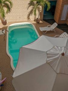 伊尔哈德博伊巴Pousada Bella Boipeba的游泳池旁带遮阳伞的游泳池
