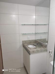 卡贝德卢Confortável Flat com piscina de borda infinita na cobertura的白色的浴室设有水槽和镜子