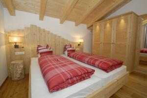 富内斯沐乐福农家乐的一间卧室配有两张带红色毯子和枕头的床