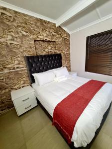 马盖特36 frere road shelly beach , margate的一间卧室设有一张大床和石墙