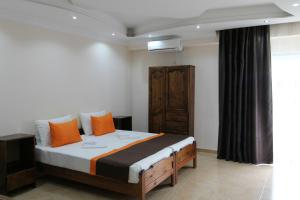 谢赫维蒂利Saba的一间卧室配有一张带橙色枕头的大床